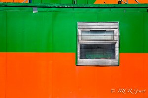 Window set into a bright portakabin of orange and green,