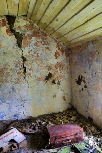 A suitcase lies on the bedroom floor of a long ago deserted farmhouse, County Cork, Ireland