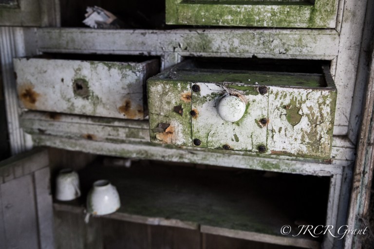 The drawer of a dresser protrudes into the old room