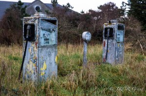 Two petrol pumps stand side by side, broken, peeling, but standing firm