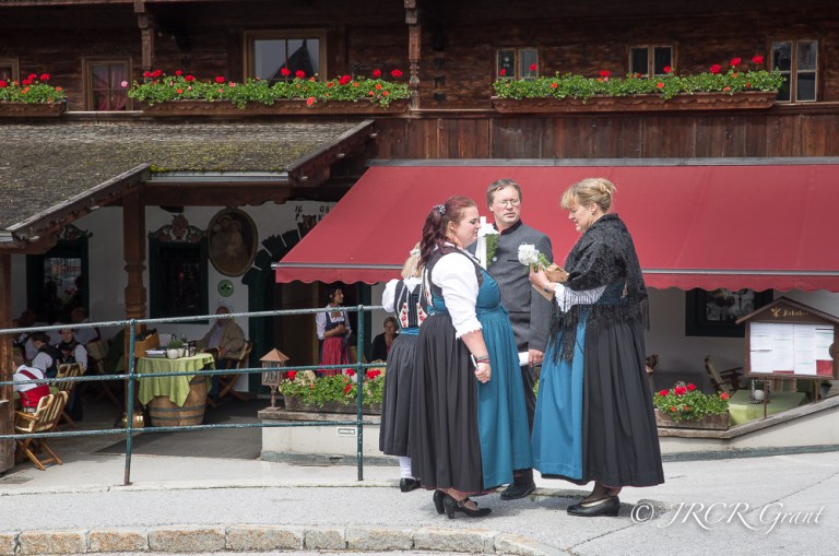 Men and woman in traditional dress in front of an Inn
