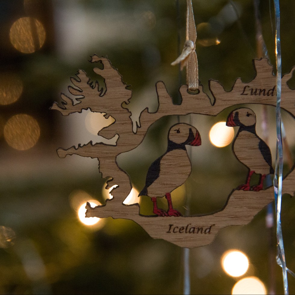 Puffins sit within an outline of Iceland