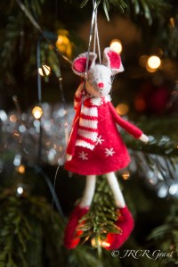 A dressed mouse hangs from a Christmas tree