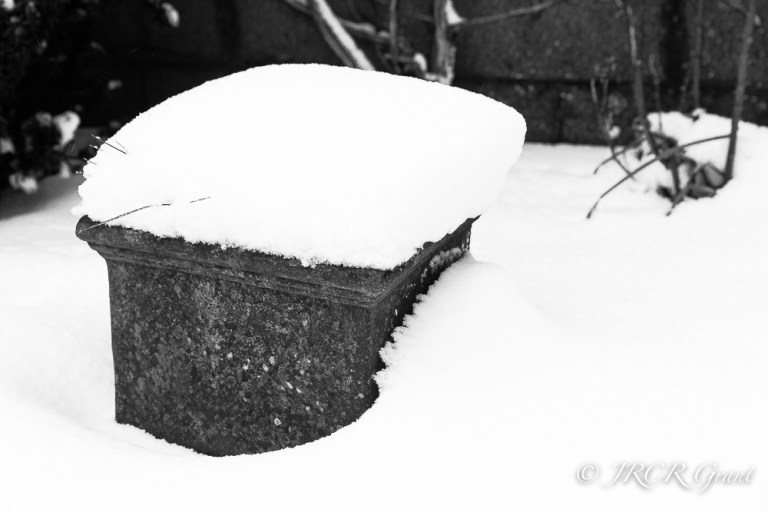 Snow wraps itself around a garden plant pot 
