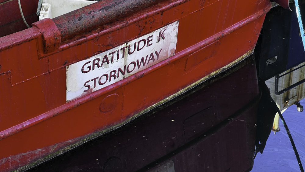 An old boat rests in Stornoway Harbour with the name Gratitude K